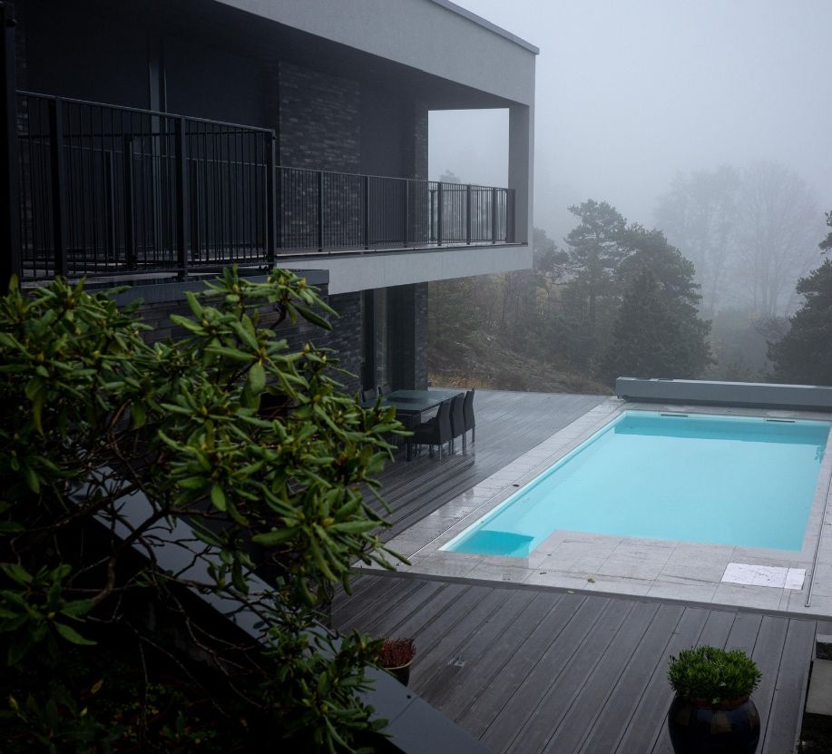 Basseng ved brunt hus